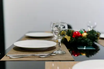 a table with a wine glass and plates on it at PANORAMA SPA ASPEN APARTMENT in Razlog