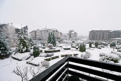 a garden covered in snow in a city at PANORAMA SPA ASPEN APARTMENT in Razlog