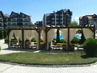 a gazebo in a park with benches and buildings at PANORAMA SPA ASPEN APARTMENT in Razlog