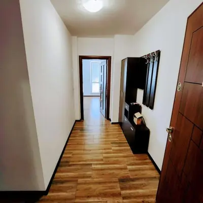 a hallway with white walls and a wooden floor at Aпартамент-София/ Newhome lux apartment in Sofia
