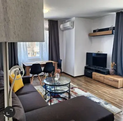 a living room with a couch and a table at Aпартамент-София/ Newhome lux apartment in Sofia