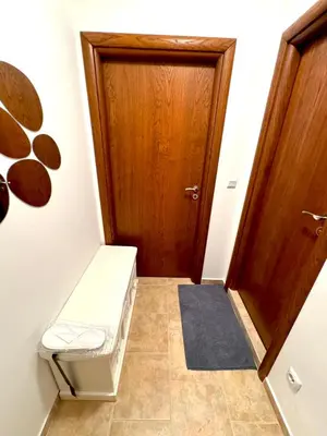 a hallway with a wooden door and a bench at Pirin Sense apartment A11 in Bansko