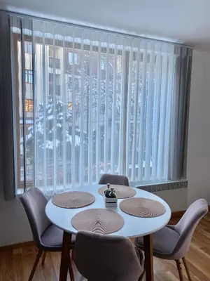 a room with a table and chairs and a large window at Pirin Sense apartment A11 in Bansko