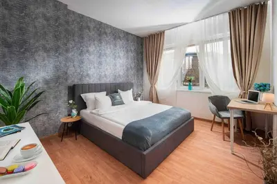 a bedroom with a bed and a table and a desk at National Palace Of Culture 1 Step Away! in Sofia