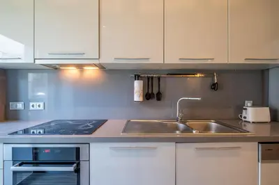 a kitchen with white cabinets and a sink at Modern yet Rustic Style City Centre Apt 2BR/2BTH in Sofia