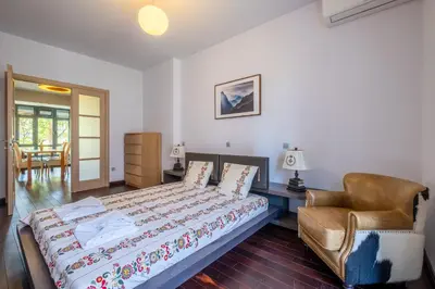 a bedroom with a bed and a chair at Modern yet Rustic Style City Centre Apt 2BR/2BTH in Sofia