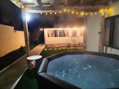 a hot tub in the middle of a yard at night at Guest House Freya in Beli Iskar