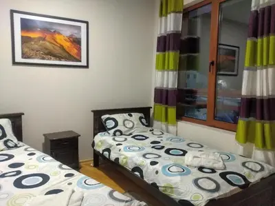 a bedroom with two beds and a window at TO FOUR+2 PREDELA 1 in Bansko