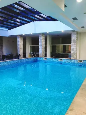 a large swimming pool with blue water in a building at TO FOUR+2 PREDELA 1 in Bansko
