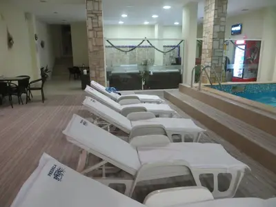a row of white lounge chairs in a swimming pool at TO FOUR+2 PREDELA 1 in Bansko