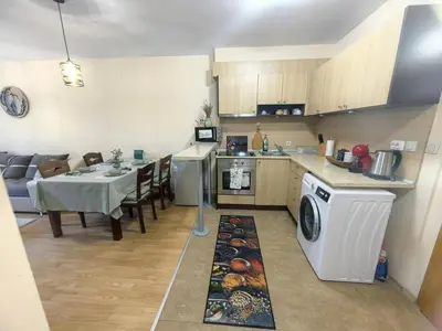 a kitchen and dining room with a table and a washing machine at Garden apartment Aspen Suites A008 in Bansko