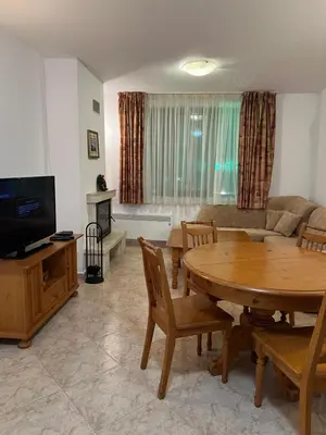 a living room with a wooden table and a couch at Скиелит 5 in Pamporovo