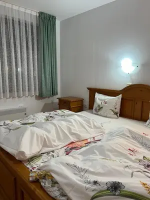 a bedroom with two beds with white sheets at Скиелит 3 in Pamporovo