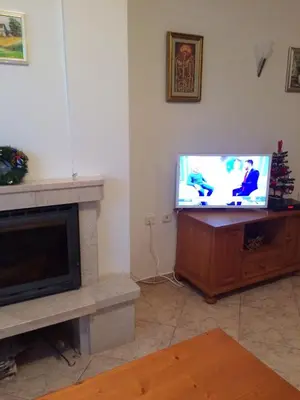 a living room with a television and a fireplace at Скиелит 3 in Pamporovo