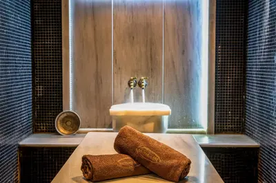 a bathroom with a sink and two towels on a tub at Мия 2 Deluxe Royal Spa in Velingrad
