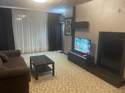 a living room with a couch and a flat screen tv at Мия 2 Deluxe Royal Spa in Velingrad
