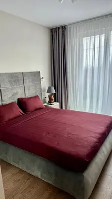 a bedroom with a large red bed with a window at Elegant Living Apartment 2 in Sofia