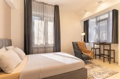 a bedroom with a bed and a chair and a desk at Victor Hugo Studio in Sofia