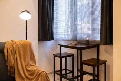 a room with a table and two stools in front of a window at Victor Hugo Studio in Sofia