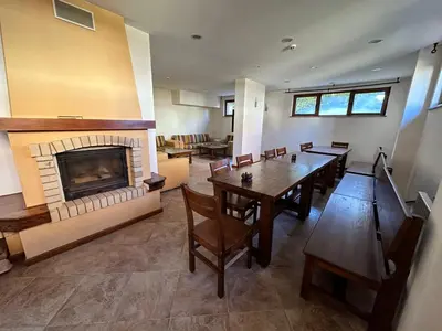 a living room with a table and a fireplace at St Ivan Rilski SPA Studio in Bansko