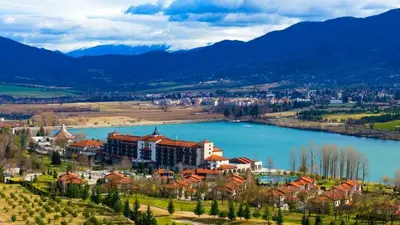 a resort on a hill next to a lake at Pravets spa resort apartments in Pravets