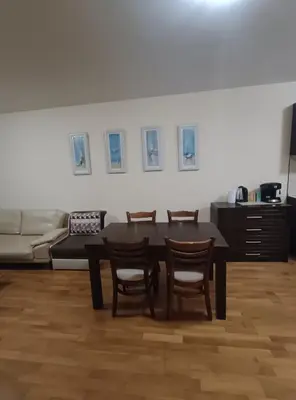a dining room with a table and chairs and a couch at Pravets spa resort apartments in Pravets