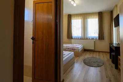 a room with a door open to a room with two beds at Rila Hills in Samokov