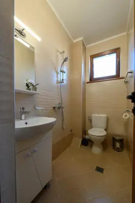 a bathroom with a sink and a toilet and a window at Rila Hills in Samokov