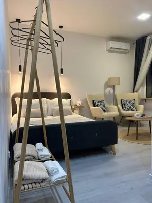 a bedroom with a bed and a living room at Pirotska Modern Room in Sofia