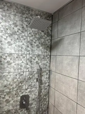 a shower with a glass door in a bathroom at Pirotska Modern Room in Sofia