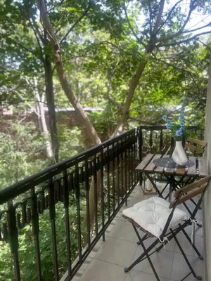 a balcony with a table and chairs and trees at Pirotska Modern Room in Sofia