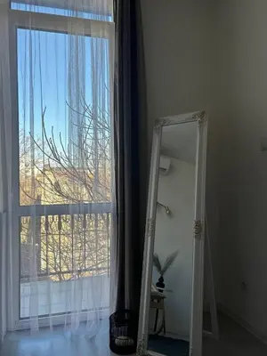 a mirror in a room with a large window at Pirostka Vintage Room in Sofia