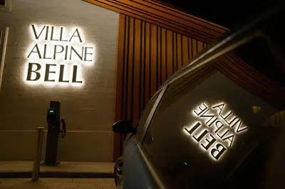 a neon sign on the side of a wall at Alpine Bell Villa in Banya