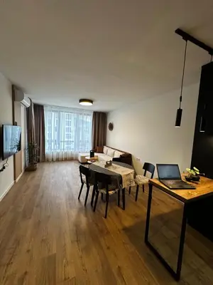 a living room with a table with a laptop on it at 1BR Modern condo near the University in Sofia