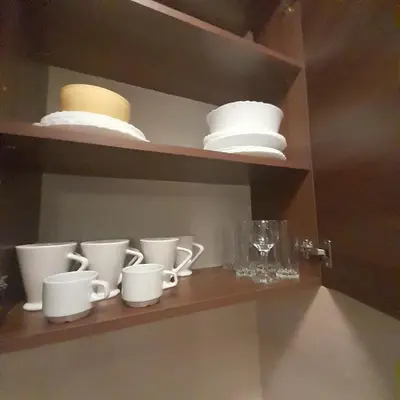 a shelf with cups and plates and glasses on it at Апартамент Belvedere G106 in Bansko