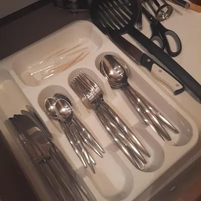 a sink with silver utensils and spoons and forks at Апартамент Belvedere G106 in Bansko