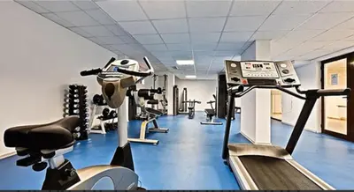 a gym with several tread machines and a treadmill at Апартамент Belvedere G106 in Bansko