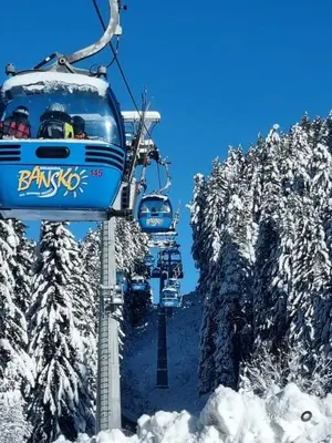 a group of people riding a ski lift in the snow at Belvedere K203 in Bansko