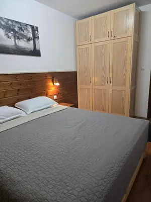 a bedroom with a large bed and wooden cabinets at Belvedere K203 in Bansko