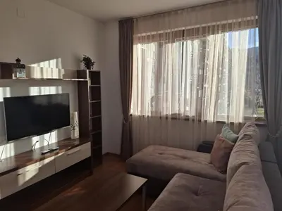 a living room with a couch and a large window at Апартаменты в Belvedere in Bansko