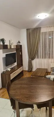 a living room with a table and a television at Апартаменты в Belvedere in Bansko