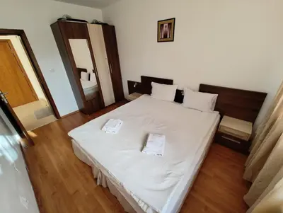 a bedroom with a white bed with two towels on it at Апартаменты в Belvedere in Bansko