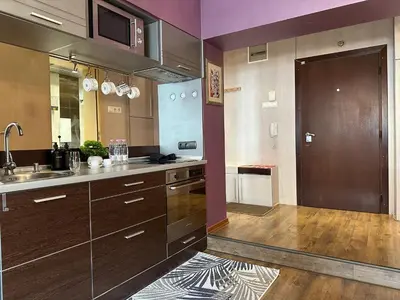 a kitchen with brown cabinets and a sink and a door at Rakovski Residence in Sofia