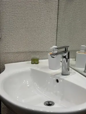 a bathroom sink with a faucet and a mirror at Rakovski Residence in Sofia
