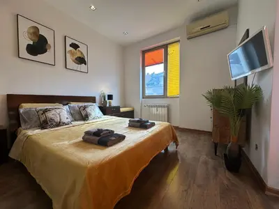 a bedroom with a large bed with a flat screen tv at Rakovski Residence in Sofia