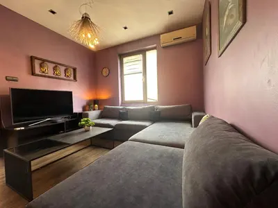 a living room with a couch and a tv at Rakovski Residence in Sofia