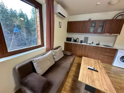 a living room with a couch and a wooden table at Pine Tree one bedroom apartment in Bansko