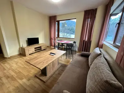 a living room with a couch and a table at Pine Tree one bedroom apartment in Bansko
