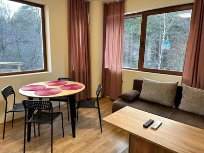 a living room with a table and a couch at Pine Tree one bedroom apartment in Bansko