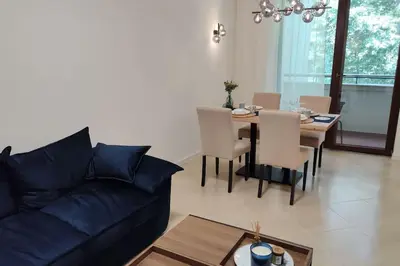 a living room with a couch and a table with chairs at Modern 2BDRM in 5* Resort & pool in Sandanski